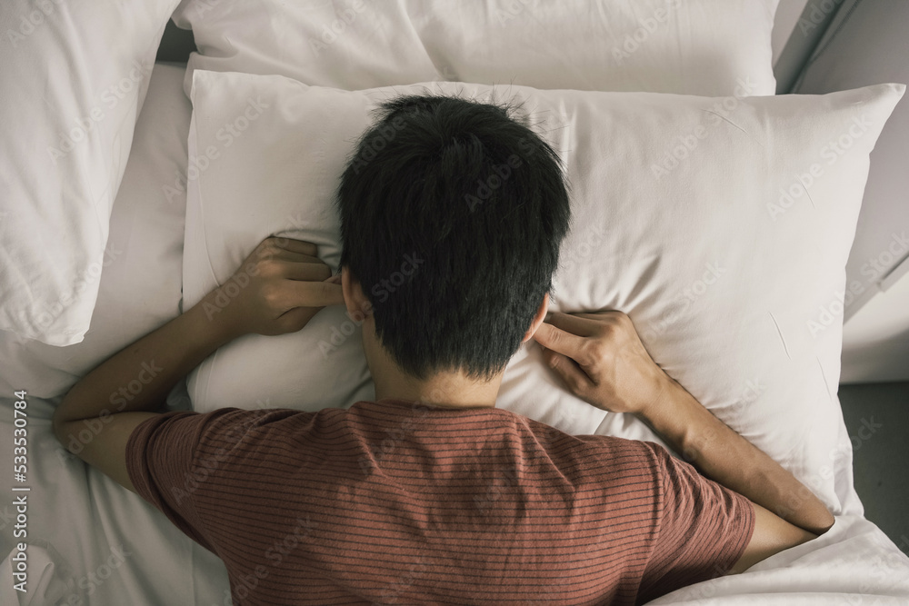 Preteen tween boy covering ears in bed, ADHD, sleep disorder, mental