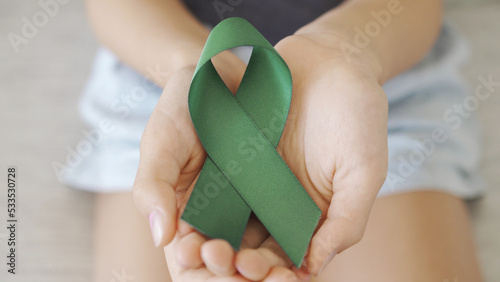 hands holding Green Ribbon, World Mental Health Day photo