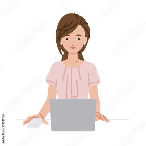 デスクで座ってPCを使っているオフィスカジュアルの女性