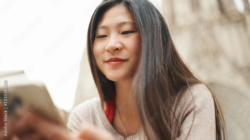 Close up Asian girl checking her social media using smartphone on the street. Pretty Asian woman looking happy outdoors. Modern technology Close up Asian girl checking her social media using smartphone on the street. Pretty Asian woman looking happy outdoors. Modern technology