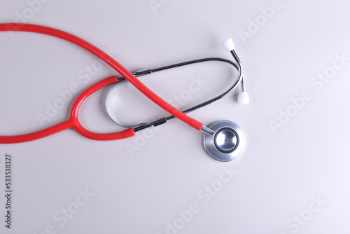 Red beautiful therapist's stethoscope on a white background