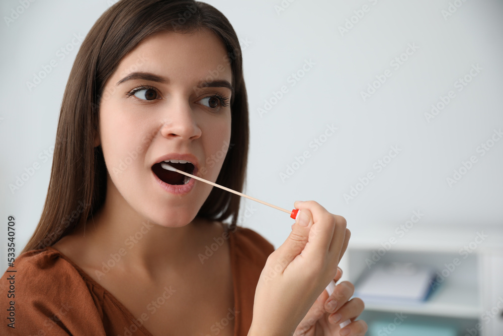Woman taking sample for DNA test indoors Woman taking sample for DNA test indoors