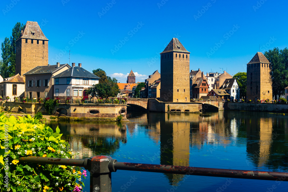 Strasbourg, Alsace, France. Barrage Vauban scenic river and architecture view on bridge Ponts Couverts with flowers