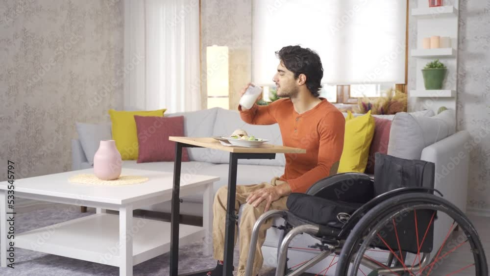 Disabled young man is happy at home and eating. Disabled young man