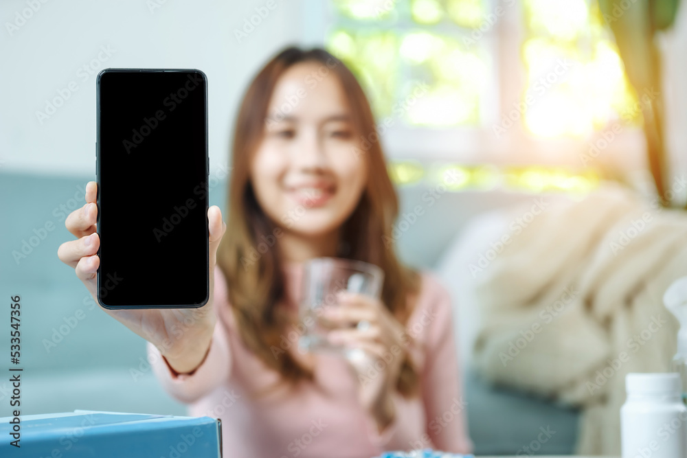 Young asian women checking pills while ordering online medicines on mobile phone at home - concept of E pharmacy, technology and healthcare Young asian women checking pills while ordering online medicines on mobile phone at home - concept of E pharmacy, technology and healthcare