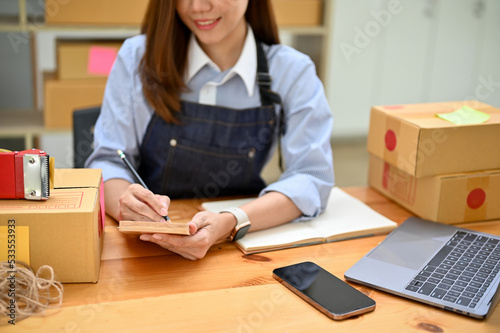 Successful young Asian female small online business entrepreneur checking her orders