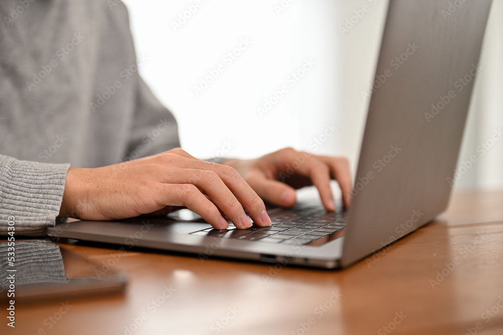 A male college student or business worker using laptop computer, typing on keyboard A male college student or business worker using laptop computer, typing on keyboard