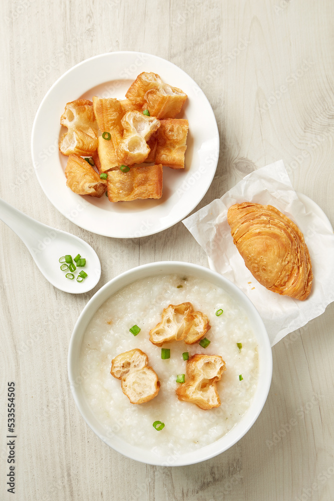 Top view of bowl of traditional Chinese porridge and fritters on woooden table. Top view of bowl of traditional Chinese porridge and fritters on woooden table.