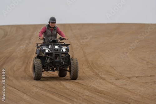 Man driving a quad bike in a sandy terrain