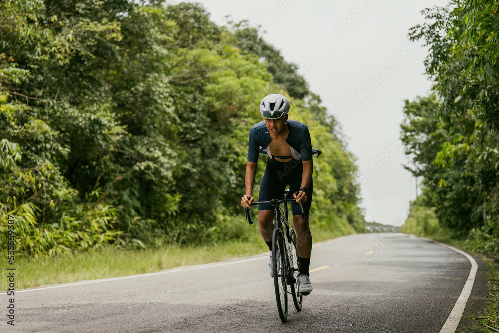 Groups of cyclists riding road bikes in the morning are climbing.