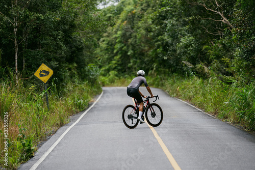 Cyclists riding road bikes in the morning are climbing. © torwaiphoto