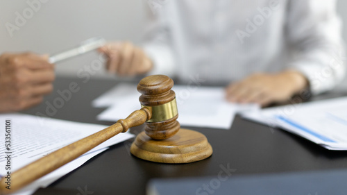 Attorney or lawyer handing client a pen to sign a business contract, Signing the contract according to the terms and conditions, scales of justice, law hammer, Concept of litigation and legal services