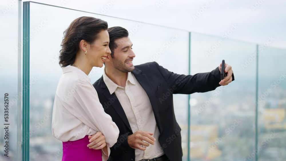 Caucasian couple celebrating holiday event having dinner at luxury skyscraper outdoor rooftop restaurant bar at summer sunset. Man and woman enjoy city lifestyle looking at city skyline in the evening
