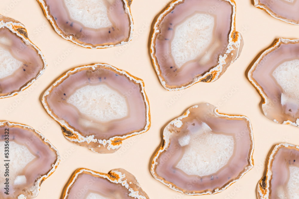 Pattern of agate crystals isolated on beige background, natural slices beautiful gemstone. Agate stone healing crystal, minimal style layout, flat lay beige pink pastel color Pattern of agate crystals isolated on beige background, natural slices beautiful gemstone. Agate stone healing crystal, minimal style layout, flat lay beige pink pastel color
