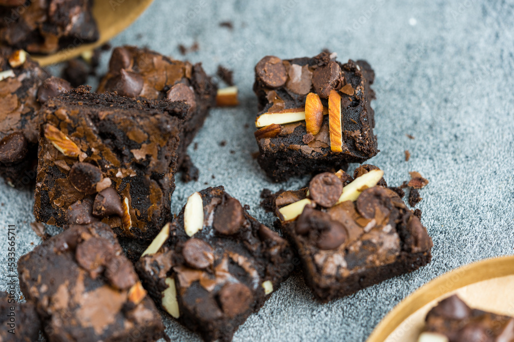 Topping of squared brownies with almond and chocolate chips. Cut pieces to fit