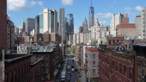 4K video with a scenic landmark view from Manhattan Bridge to China Town apartment buildings and streets. Skyscraper office buildings in background. New York, 2022.