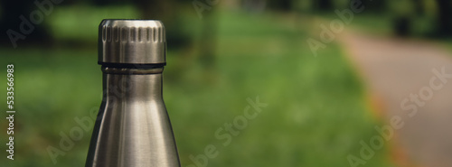 Water bottle. Reusable steel thermo water bottle on green grass. Sustainable lifestyle. Plastic free zero waste free living. Go green Environment protection. Health-conscious. Steel thermo water