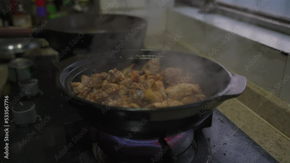 A chef in a Cantonese kitchen is making a Cantonese-style chicken casserole A chef in a Cantonese kitchen is making a Cantonese-style chicken casserole