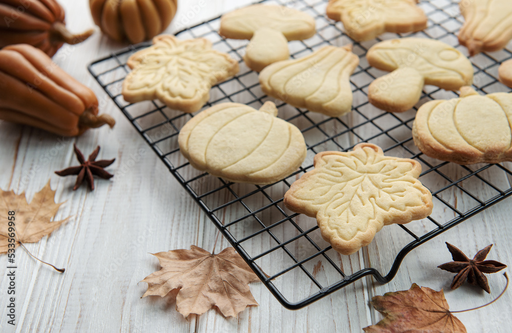 Cookies shaped like pumpkin and leaves on rustic wood background Cookies shaped like pumpkin and leaves on rustic wood background