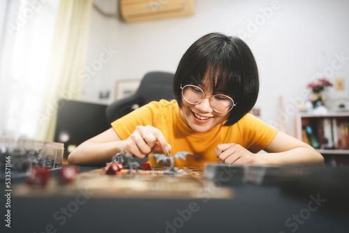 Young adult asian woman enjoying role playing tabletop and board games