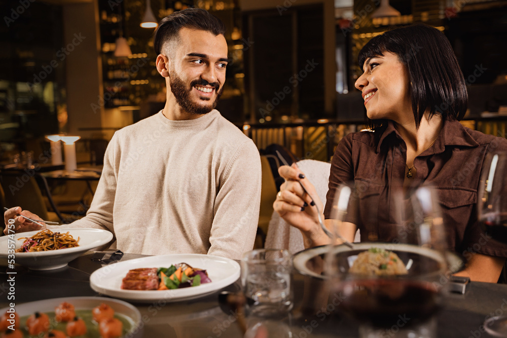 Happy couple dining at restaurant watching in each other eyes