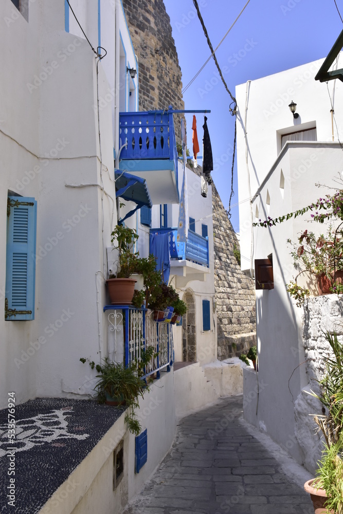 White houses with blue shutters, balconies, the traditional Greek village of Mandraki on the island of Nisyros.