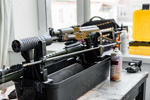фотографія Automatic rifle on stand on the table of the weapons workshop.
