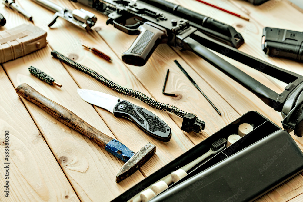 Disassembled rifle with cleaning tools on table of weapons workshop Disassembled rifle with cleaning tools on table of weapons workshop
