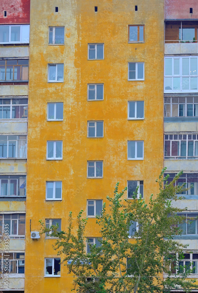 Fragment of the facade of an old multi-storey residential building on an autumn day