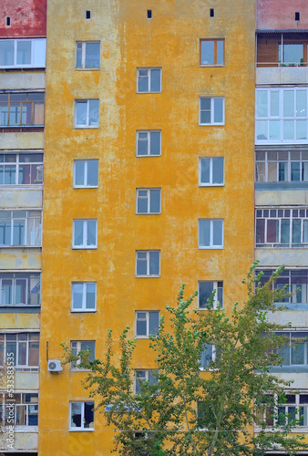 Fragment of the facade of an old multi-storey residential building on an autumn day