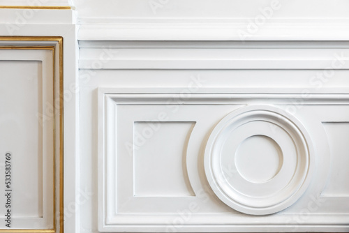 Molded white wall decoration with golden lines,