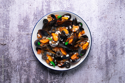 Steamed mussels with tomato sauce and feta cheese. Typical Greek recipe.