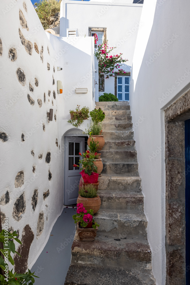 Fototapeta premium Ceramic flower pots on steep stone steps at Imergovigli, Santorini, Greece