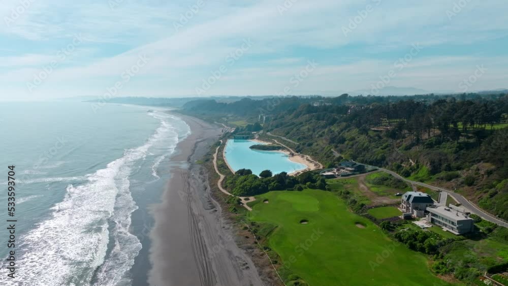 Aerial orbit of a swimming pool simulating an artificial beach in an exclusive condominium, Santo Domingo, Chile.