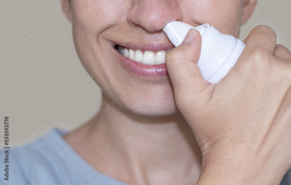 sore throat and runny nose treatment. woman using lozenge candy spray for red painful throat or
