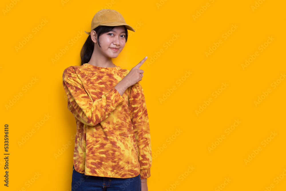 young asian woman pointing with fingers to different directions isolated on yellow background
young asian woman pointing with fingers to different directions isolated on yellow background