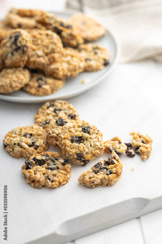 Wholegrain oat cookies. Cookies with oatmeal and raisins on white table. Wholegrain oat cookies. Cookies with oatmeal and raisins on white table.