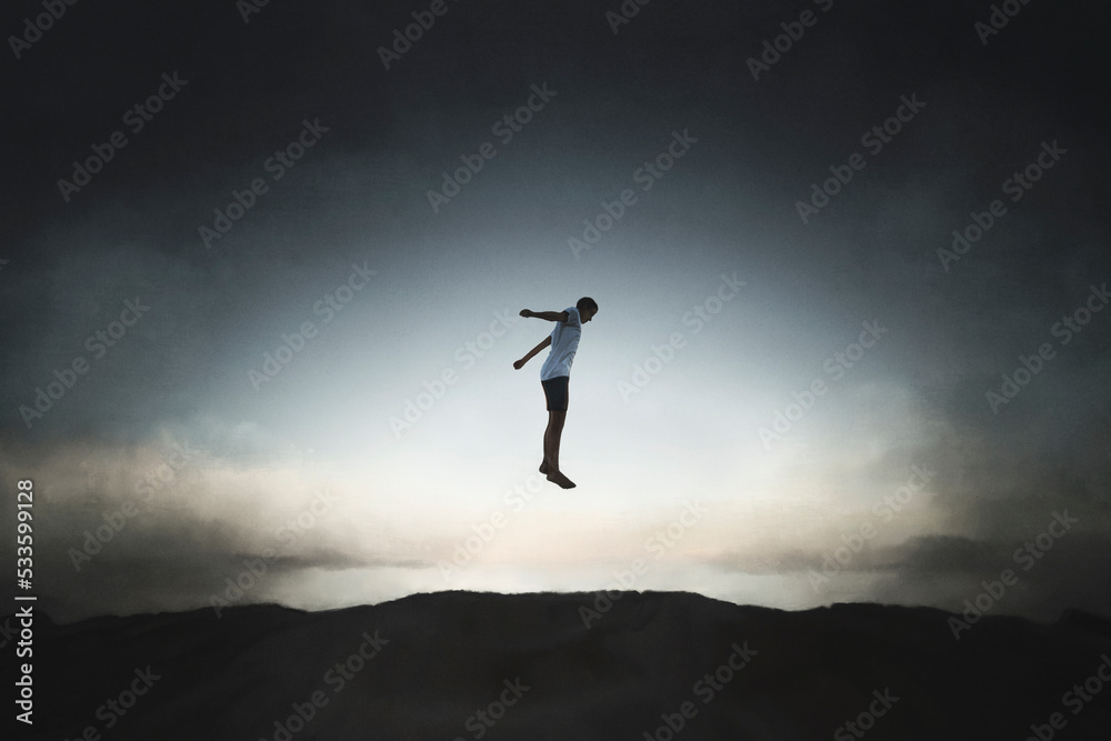 silhouette of a happy boy jumping almost touching the sky, concept of freedom and success