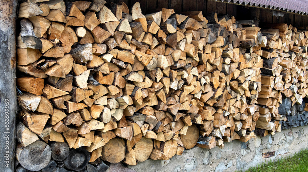 Shed for storing firewood in the village. Wood for heating. Copy space for text, firewood wall Shed for storing firewood in the village. Wood for heating. Copy space for text, firewood wall