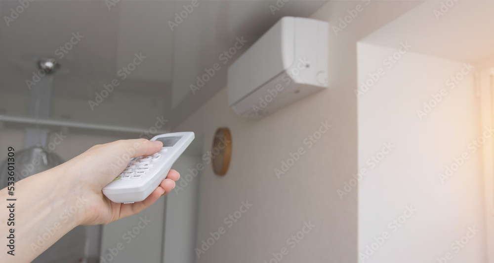 Management of a wall split system in the office using a control panel. Air conditioner in the room. Modern air conditioning, freshness and coolness. Copy space for text Management of a wall split system in the office using a control panel. Air conditioner in the room. Modern air conditioning, freshness and coolness. Copy space for text