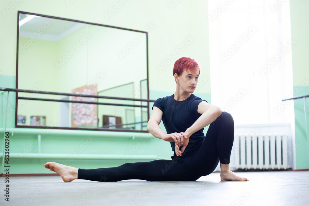 Fototapeta premium Female dancer stretching before choreography practice. Physical exercises are important for avoiding muscle strains