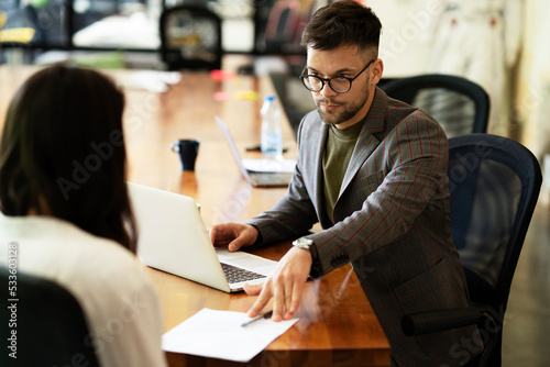 Fotografia Businessman gives businesswoman dismissal contract to sign.