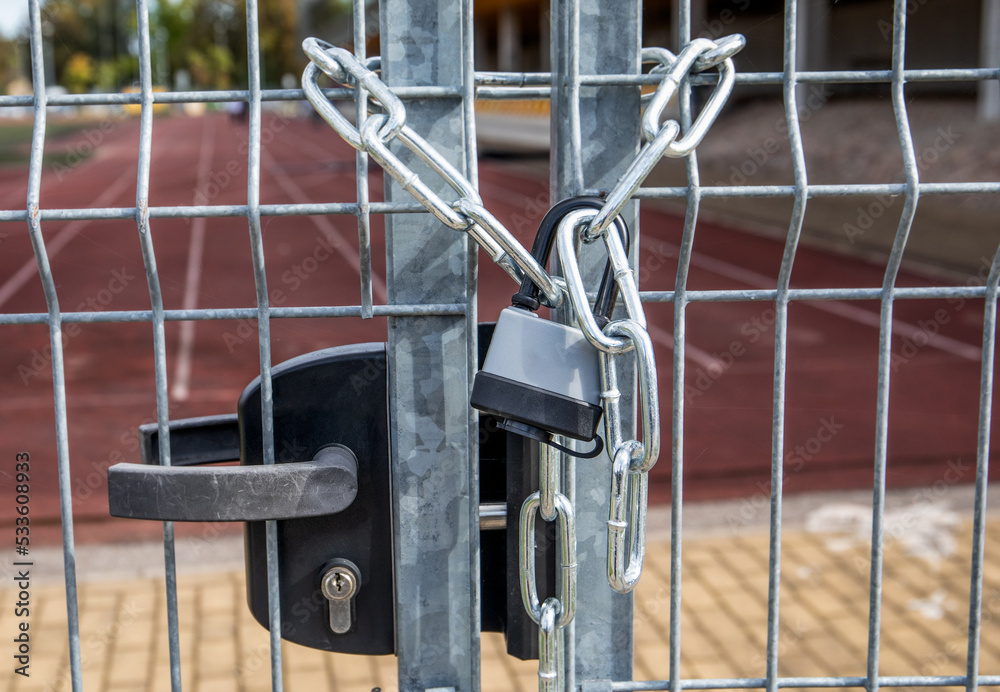 Locked metal gate with chain and padlock Locked metal gate with chain and padlock