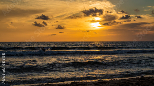 Surfing in the sunset light in Sardinia