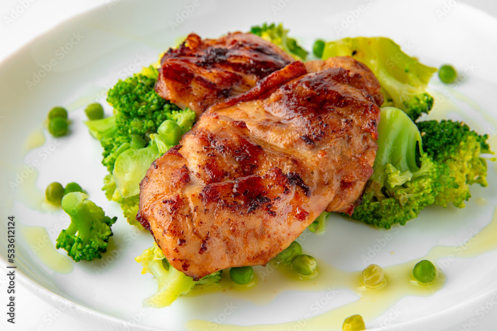 Steak with chicken or turkey with vegetables. Balanced, nutritious, tasty and nutritious food. Ready-made menu for a restaurant or for delivery. Dish in a white plate isolated on a white background. Steak with chicken or turkey with vegetables. Balanced, nutritious, tasty and nutritious food. Ready-made menu for a restaurant or for delivery. Dish in a white plate isolated on a white background.