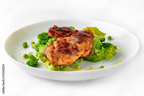 Steak with chicken or turkey with vegetables. Balanced, nutritious, tasty and nutritious food. Ready-made menu for a restaurant or for delivery. Dish in a white plate isolated on a white background.