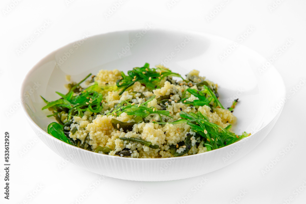 Wheat porridge or bulgur with seaweed and chukka. Balanced, nutritious, tasty and nutritious food. Ready-made menu for a restaurant or for delivery. Dish in a white plate isolated on a white Wheat porridge or bulgur with seaweed and chukka. Balanced, nutritious, tasty and nutritious food. Ready-made menu for a restaurant or for delivery. Dish in a white plate isolated on a white