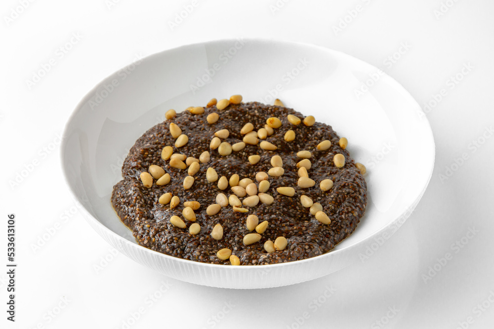Chia with pine nuts. Balanced, nutritious, tasty and nutritious food. Ready-made menu for a restaurant or for delivery. Dish in a white plate isolated on a white background. Chia with pine nuts. Balanced, nutritious, tasty and nutritious food. Ready-made menu for a restaurant or for delivery. Dish in a white plate isolated on a white background.