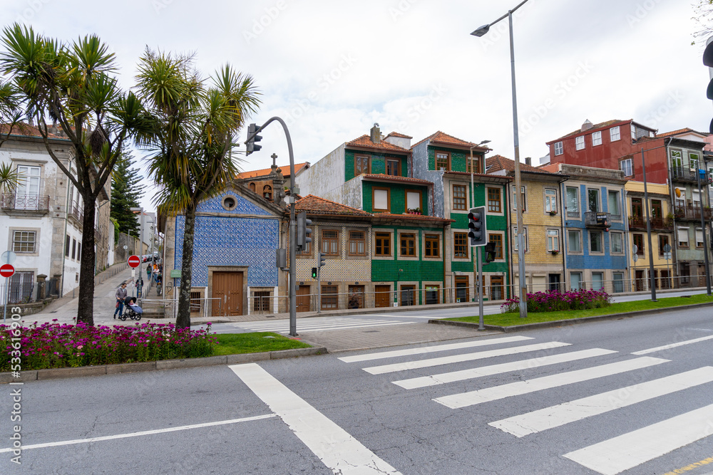 Porto street, with the houses and their tiled facades, with a traffic light, on a cloudy day.