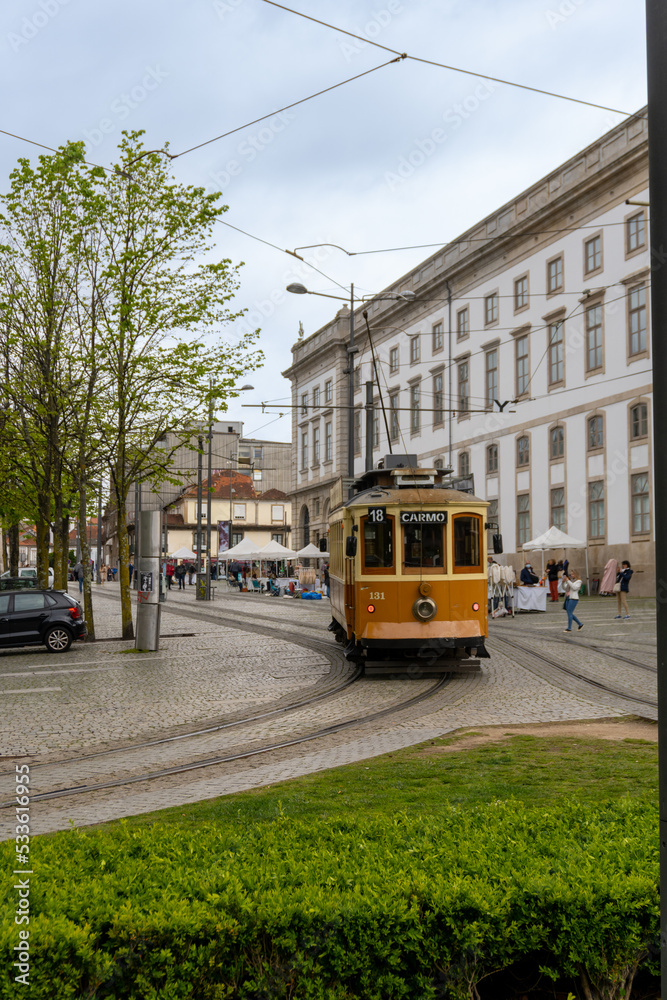 Old yellow tram of the city of Porto, going through the streets.